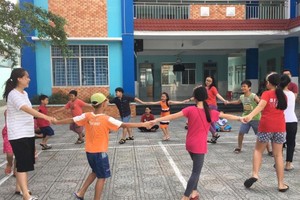 輔導員與少兒一起參加集體遊戲。