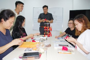 陳志明校長(中)正在指引學員製作粽子香囊。