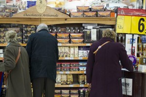 圖為民眾在超市貨架前挑選商品。 （圖源：AFP）