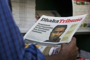 這張照片中，一名孟加拉國男子在看報，報紙首頁顯示的是有關孟加拉國男子烏拉（Akayed Ullah）的新聞。現年28歲的孟加拉國移民烏拉被指控在紐約地鐵裡引爆自製炸彈。（圖源：AP）