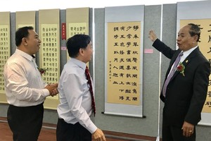 馮利發（左二）與林漢城（左一）陪同柬埔寨教育部國務秘書麥砂綸參觀越南區書法。