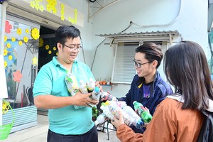 來自同奈省的年輕人把生態磚塊成品交給 武仲廷副書記（左）。