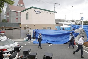 日本大阪府吹田市16日發生警員遇襲佩槍遭搶事件，警方在案發現場進行調查。*（圖源：路透社）