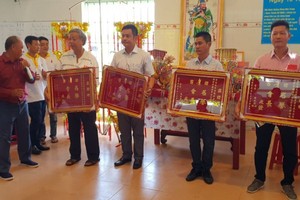 鄭成龍理事長向各熱心人士贈送紀念金牌。