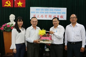 本報編輯部主任范興(左二)接受代表團的賀禮。