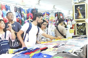 遊客在濱城市場購物。