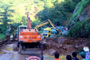 救援力量在清理盤山道的大量沙石。（圖源：懷清）