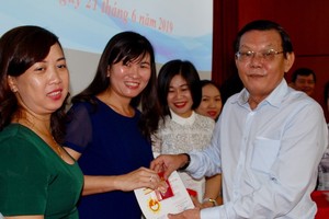 《西貢解放報》總編輯阮晉豐向本報幹部頒發紀念章。