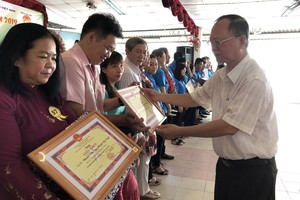 穗城會館理事長盧耀南向越華模範家庭頒發獎狀。