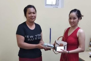 清潔工人陳氏知（左）將拾到的財物交還失主阿瓊。（圖源：峴港報）