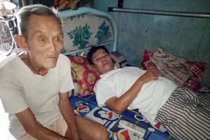 楊蝦伯伯與癱瘓在床的長子錦雄。