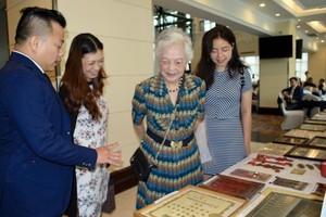 麒麟(左一)向華人同胞介紹其收藏的老堤岸事物。