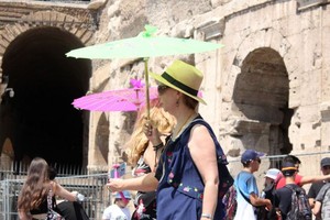 6月28日，在意大利羅馬鬥獸場，人們撐傘遊覽躲避烈日。（圖源：新華社）