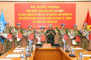 國防部副部長阮志詠上將向前往南蘇丹與中非共和國參與聯合國維和行動的軍官頒授國家主席《決定》和贈送鮮花祝賀。（圖源：嬌江）