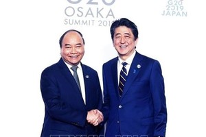 政府總理阮春福（左）與日本首相安倍晉三握手。（圖源：越通社）