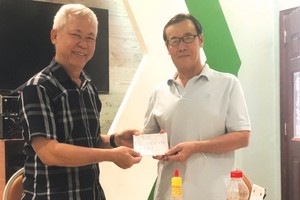 徐有燦（左）報效本報社會慈善金予本報代表接領。