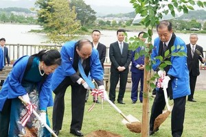 阮春福總理偕夫人和自民黨幹事長、日越友協聯盟主席二階俊博在紀之川市共同種下櫻花樹以記取這次特別的事件。（圖源：VOV）