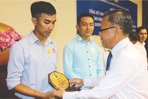 市委民運處主任阮友協向出色勞動者頒發紀念章。（圖源：互聯網）