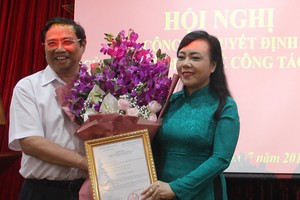 衛生部長阮氏金進（右）從黨中央政治局委員、中央組織部長范明正手中接過委任《決定》及祝賀鮮花。（圖源：L.K）