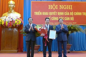 新任河江省委書記鄧國慶（中）接過人事委任《決定》和鮮花祝賀。（圖源：河江報）