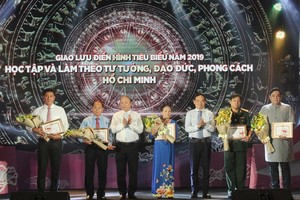 中央宣教部副部長武文鋒（左三）、市委常務副書記陳留光（右三）向學習與傚法胡志明思想、道德、作風取得成績的5位典範人士頒授紀念章和證書並贈送鮮花祝賀。（圖源：長黃）