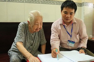 新平郡第七坊人委會司法幹部指引老人家寫授權書代領退休金。