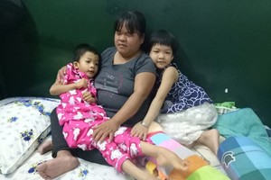 許垂玲抱著四肢癱瘓的幼女薔薇。