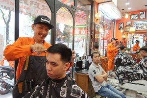 鄭懷清正給客人理髮。