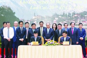 政府總理阮春福（前中）見證老街省人委會與各企業簽署投資協議書。（圖源：Chinhphu.vn）