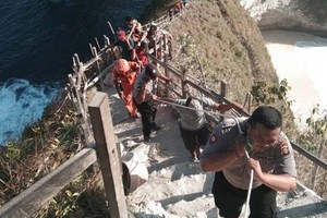 救援隊員將罹難者的屍體運出懸崖。（圖源：Nusa Bali）