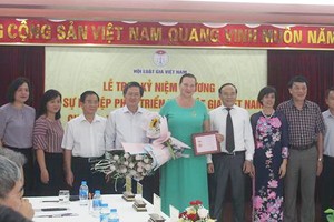 俄羅斯“和平之路”國際基金主席烏姆諾瓦‧伊琳娜‧安納托利耶夫納教授（中）榮獲“為越南法學家協會發展事業”紀念章。（圖源：P.Mai）