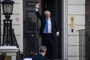 當選英國保守黨領袖的鮑里斯‧約翰遜抵達保守黨總部後揮手。（圖源：新華社）
