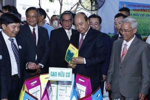 政府總理阮春福（前右二）參觀堅江企業商品展。（圖源：越通社）