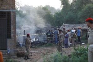 安全人員在墜機現場進行勘察。（圖源：新華社）