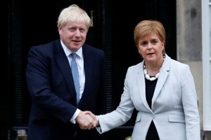 蘇格蘭政府首席大臣斯特金（右）與約翰遜握手時木無表情。（圖源：AP）