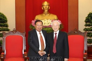 黨中央總書記、國家主席阮富仲(右)接見老撾人民革命黨中央總書記、國家主席本揚‧沃拉吉。（圖源：越通社）