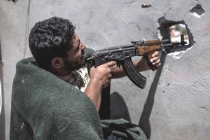 7月31日，在利比亞的黎波里，利比亞民族團結政府武裝人員與利比亞“國民軍”武裝（不在畫面中）交戰。（圖源：新華社）