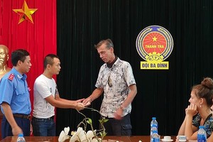 范越僑（左二）向被“宰”的乘客道歉並退還所宰的錢款。（圖源：Q.P）