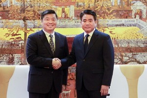 河內市人委會主席阮德鍾（右）與中國廣東省副省長歐陽衛民握手合影。（圖源：秀英）