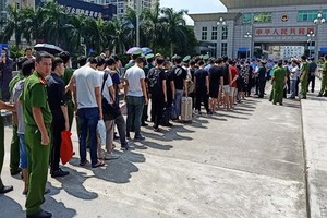 我國警方在中國廣西東興市北崙河大橋向中國警方移交28名網絡犯罪嫌疑人，以及電腦、手機等一批作案工具。（圖源：警方提供）