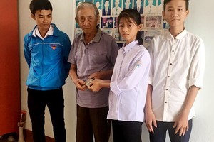 拾金不昧的兩高中生阮氏草（右二）和陳國孝（右一）將拾到的錢款交還失主。（圖源：新琪）