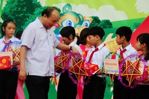 政府總理阮春福向廣南省大祿縣清貧少兒贈送中秋節禮物。（圖源：霸勇）