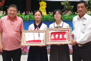 杭慰瑤董事長(左一)向學生頒發“品學兼優”金牌。