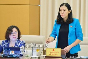 國會司法委員會主任黎氏娥闡（右）在會議上述政府對肅貪工作的審查《報告》。（圖源：Quochoi.vn）