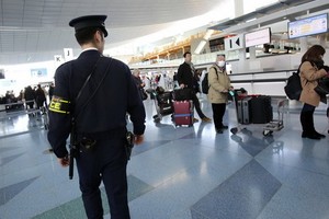 一名日本東京都警視廳反恐小組的警察在羽田機場國際到達航站樓內執勤。（圖源：AP）