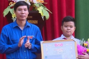 拾遺不昧的七年級A班學生阮平明（右）獲頒發該省共青團執委會的獎狀。（圖源：越通社）