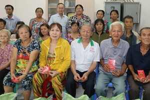 范興主任(後排左三)向貧困戶贈送禮物。