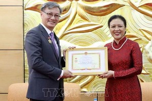 越南各友好組織聯合會主席阮芳娥（右）向老撾駐越南大使通沙萬‧豐威漢頒贈“為各民族之間和平友好”紀念章。（圖源：越通社）