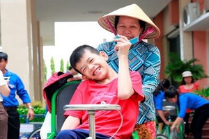 隆安省一名落葉劑受害少兒在獲贈手搖輪椅後的喜悅。