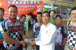 車隊代表把之前所募捐到的1億6900萬元善款與物資轉交給教養院的負責人。